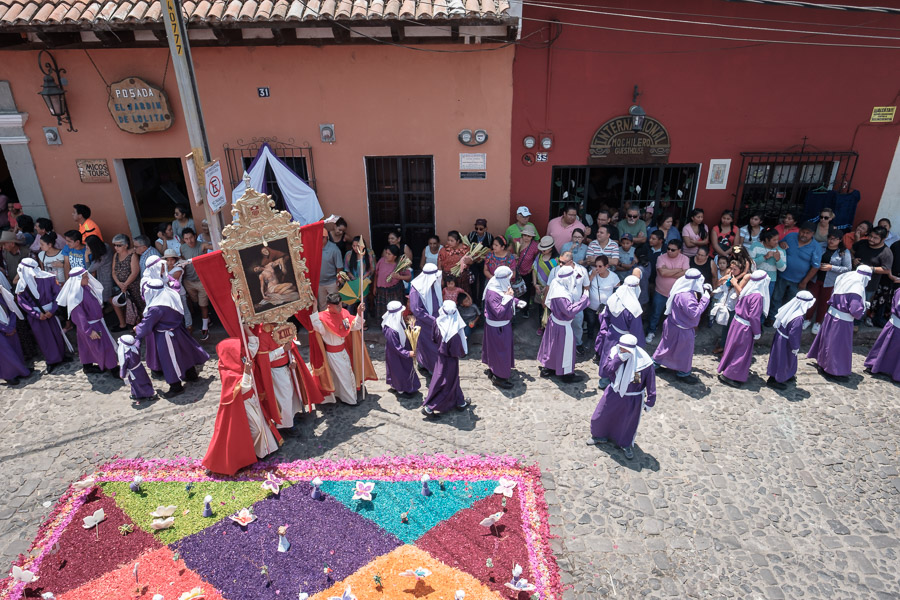 Signs bearing vivid imagery of Jesus’ suffering herald the beginning of a Palm Sunday procession.