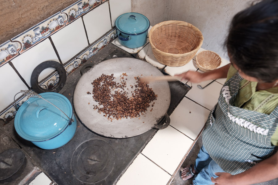 Lydia roasts coffee the traditional way: stirring beans in a hot cast iron skillet fed by a wood fire beneath.