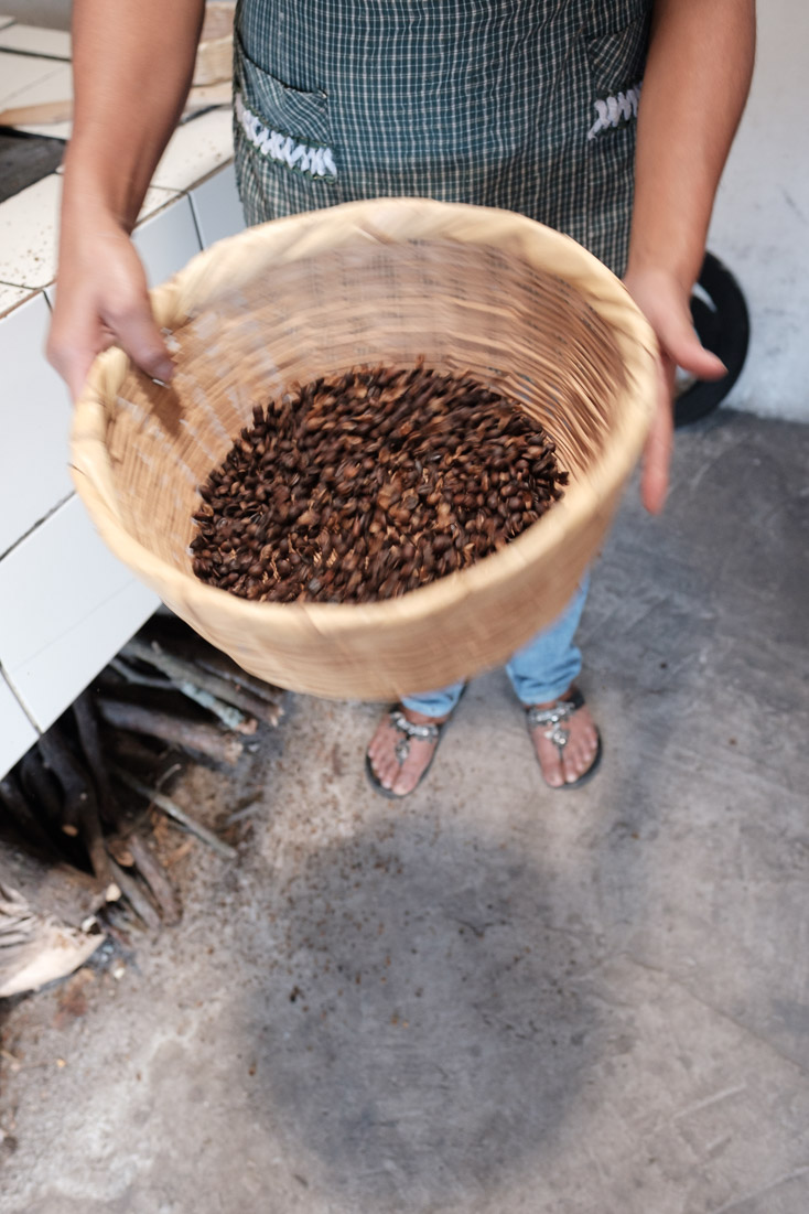 Shaking the chaff from freshly roasted coffee.