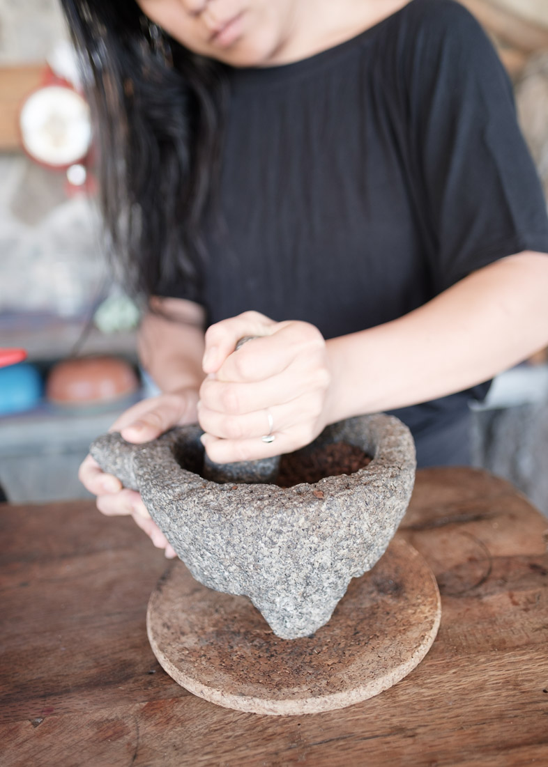 Hand grinding coffee with mortar and pestle.