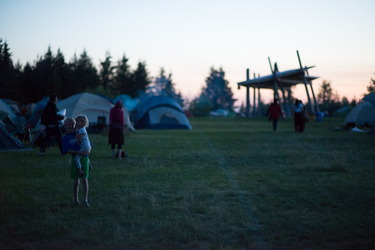Wanderers of the festival campground at dusk. This year, new shelters were built as places for gatherings (pictured in the distance here). Each of these took on a life of their own: be it anything from a web of slacklines for everyone to use to a place for impromptu music jams.