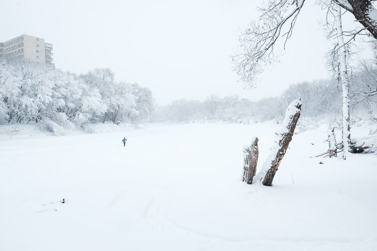 A cross country skier puts fresh tracks on the river.